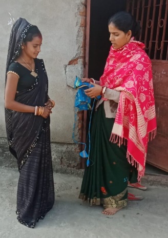 Preety shows a garment to an SPS volunteer