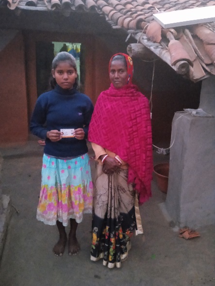 A beneficiary family shows an Ayushman card